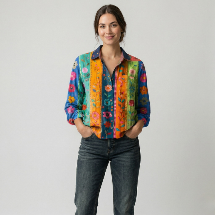 Woman wearing a vibrant multi-colored vertical striped shirt with dark denim jeans.
