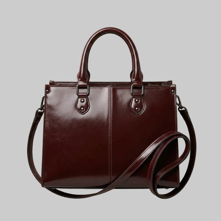 Brown leather handbag with a shoulder strap on a beige background