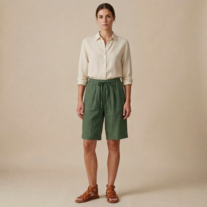 Woman wearing a white shirt and green shorts against a beige background