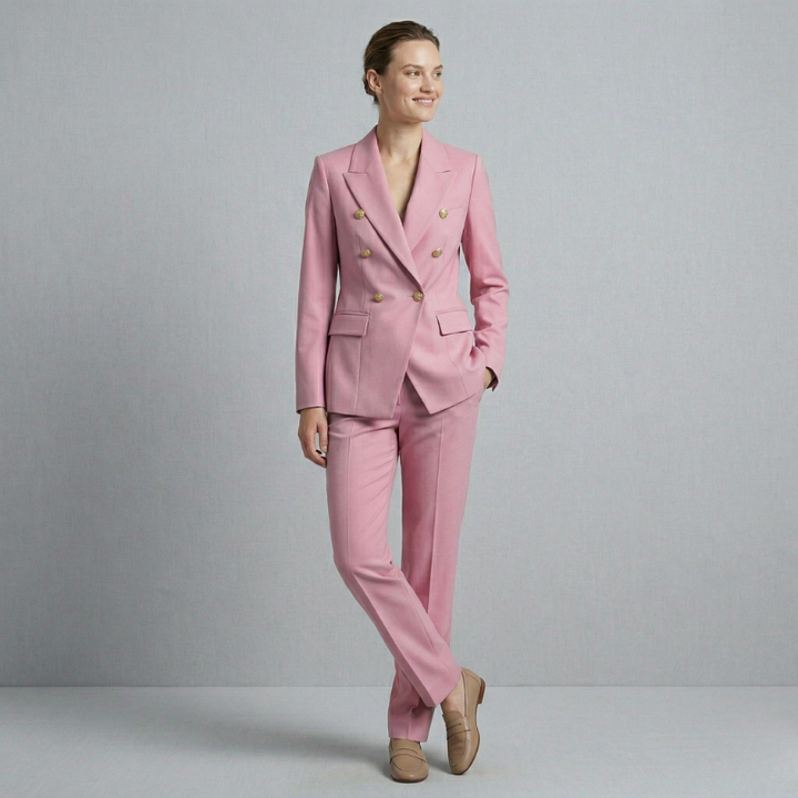 A modern pastel pink two-piece business suit featuring a double-breasted closure and gold-toned buttons.