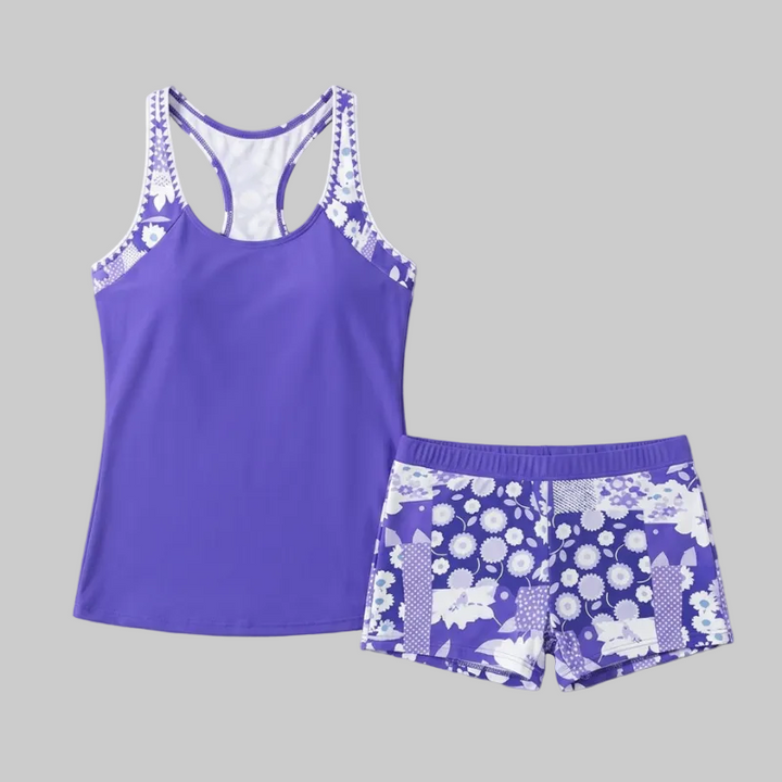A two-piece purple tankini swimsuit set featuring a racerback top and matching floral print boy shorts.