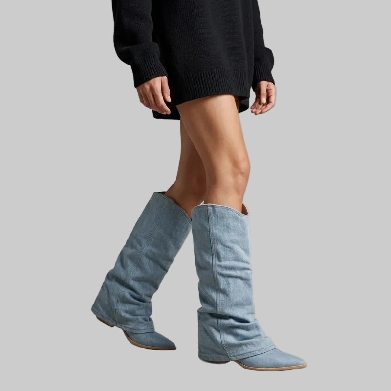 Person wearing blue knee-high boots with a plain background