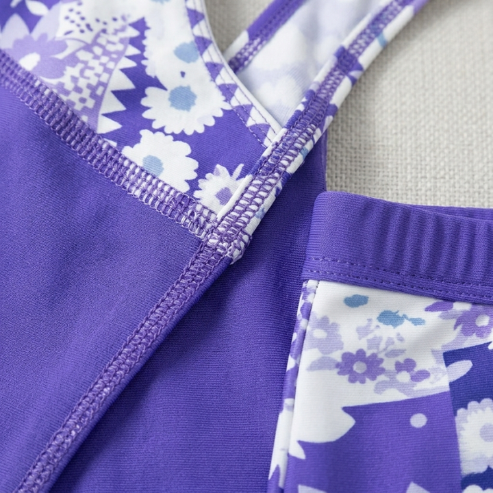 Extreme close-up showing the high-quality stitching and floral pattern detail on the purple tankini set.