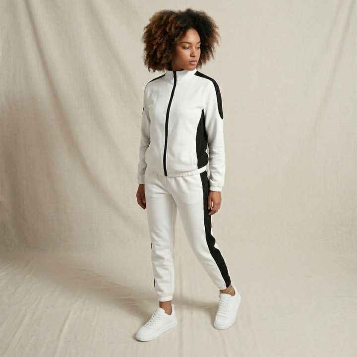 Person wearing a white and black tracksuit on a beige background