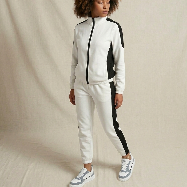 Person wearing a white and black tracksuit on a beige background